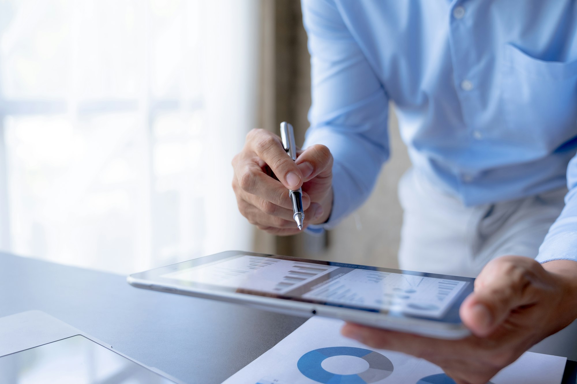 Focused businessman using tablet to analyze statistical data.